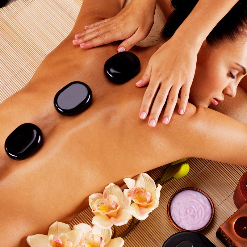 Hot stone massage using heated basalt stones at Dragon Massage, Anna Bay